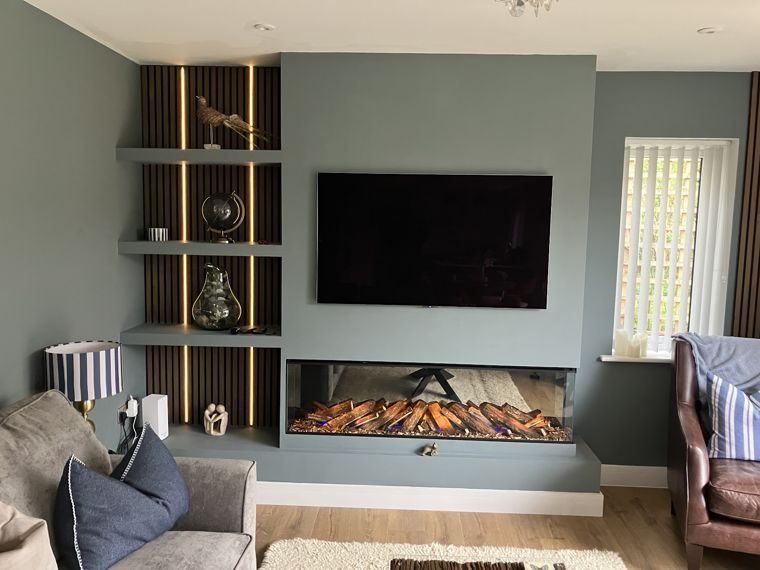 A media wall with lit slatted alcove shelves, an inset fire and a wall-mounted TV